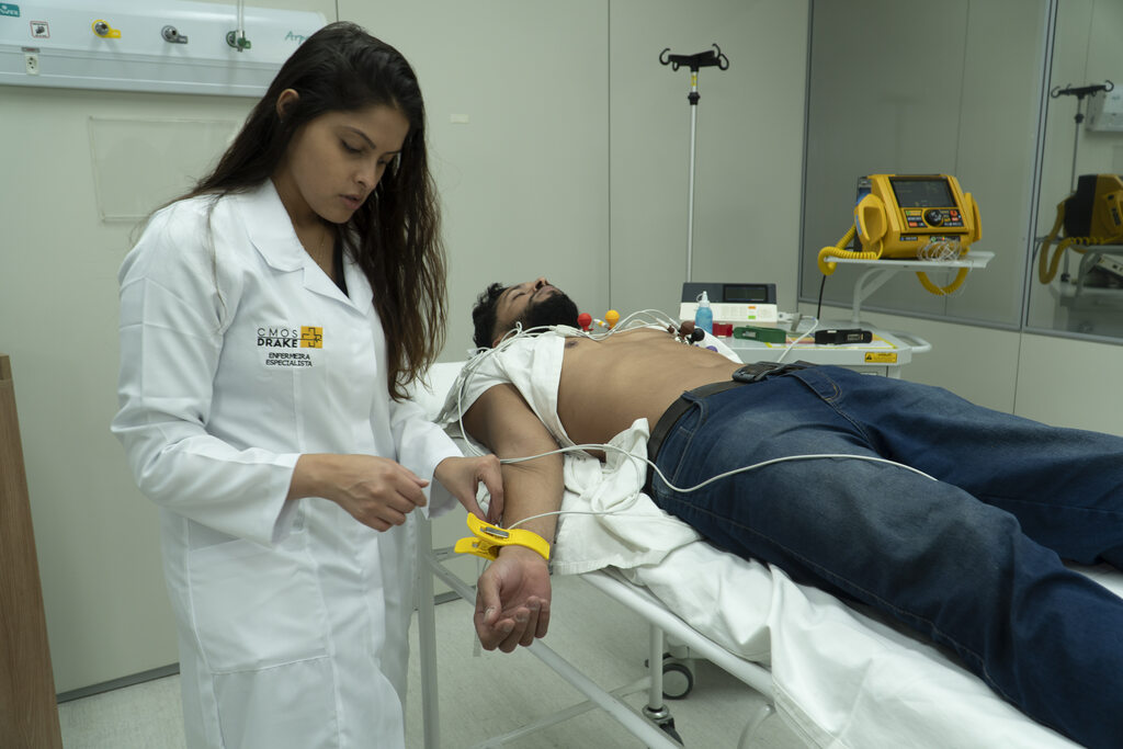 médica examinando paciente por meio do eletrocardiógrafo